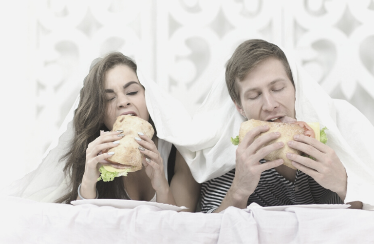 Entspannung zum Einschlafen - Paar isst Sandwich im Bett